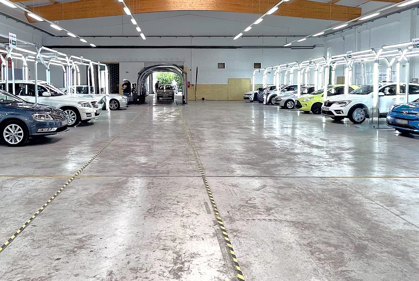 Das Bild zeigt eine Halle in Kassel, die nach einem Massenschadenereignis eingerichtet wurde, um die beschädigten Fahrzeuge von Kfz-Sachverständigen begutachten zu lassen. Die Fahrzeuge durchfahren zunächst einen Hagelscanner, der die Dellen vorab erfasst. Anschließend erstellt der Sachverständige das genaue Kfz-Gutachten. Das gesamte Schadenmanagement – von der Erfassung über die Terminierung bis hin zur Verwaltung der Schadenfälle – wird durch das myConnect Massenschadenportal effizient organisiert und verwaltet.