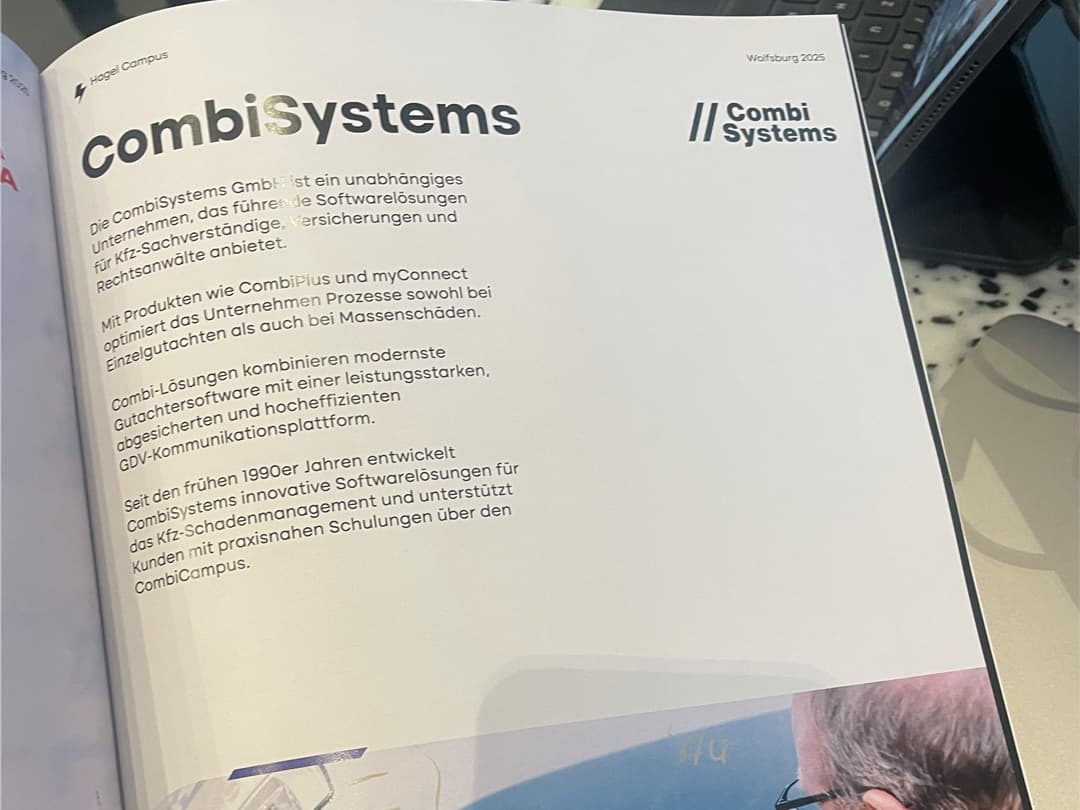 Eine aufgeschlagene Seite aus dem HagelCampus-Journal 2025, auf der ein Artikel über CombiSystems zu sehen ist. Der Text beschreibt CombiSystems als führenden Anbieter von Softwarelösungen für Kfz-Sachverständige, Versicherungen und Rechtsanwälte. Erwähnt werden die Produkte CombiPlus und myConnect sowie die langjährige Erfahrung des Unternehmens seit den 1990er Jahren. Im Hintergrund liegt ein Tablet oder Laptop auf einem Tisch.