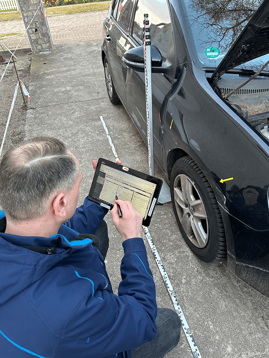 Sorgfältig und mit moderner Technik dokumentiert Enrico Rehberg einen Unfallschaden an einem Fahrzeug. Ausgestattet mit Tablet, digitalem Messsystem und einem geschulten Auge trägt er alle relevanten Informationen direkt in die Schadensoftware ein.