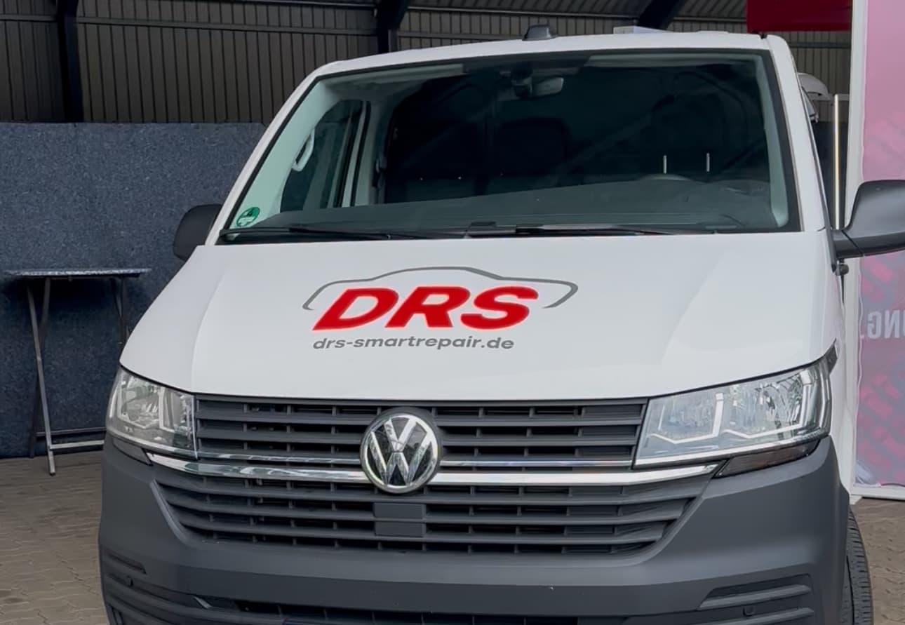Vorderansicht eines weißen Volkswagen-Transporters mit dem Logo „DRS“ und der Webadresse „drs-smartrepair.de“ auf der Motorhaube, aufgenommen auf dem LeeseDay.