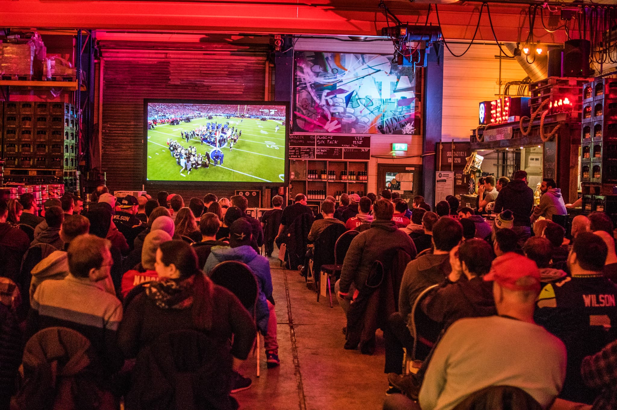 Volle Halle beim Super-Bowl-Public-Viewing in der Landgang Brauerei – große Leinwand, amerikanisches Football-Feeling und volle Sitzreihen.