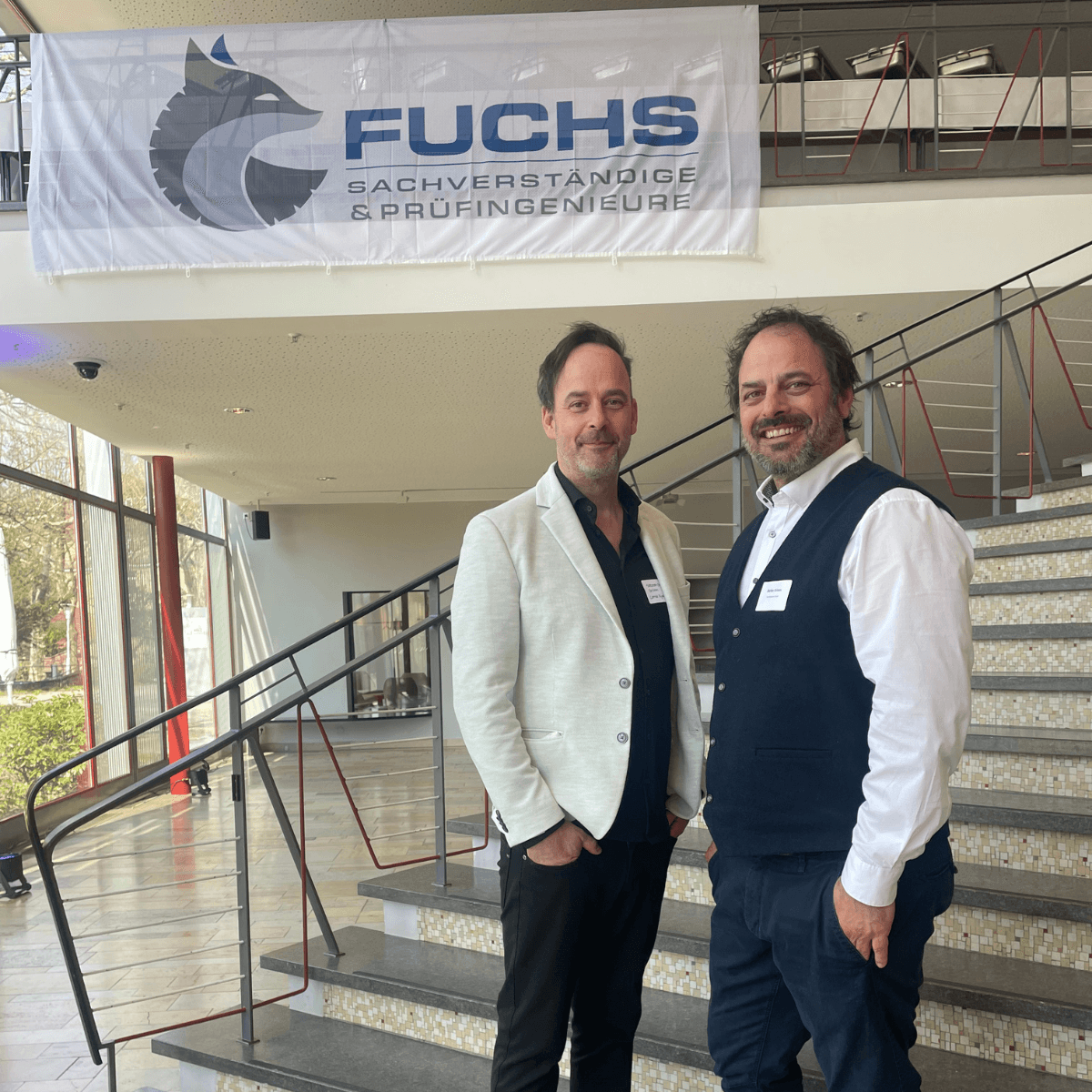 CombiBrüder Grimm bei der Hagelakademie in Göppingen. Sie stehen auf einer Treppe und lachen in die Kamera.